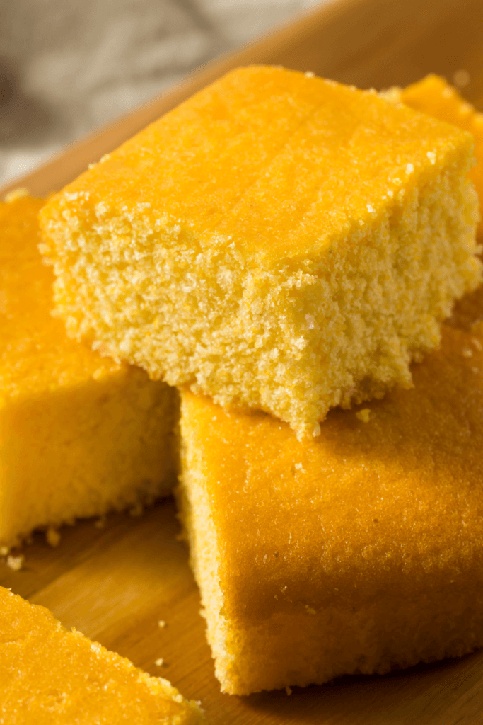 Several pieces of Southern cornbread, cut into square pieces, with a golden-yellow color and slightly crumbly texture.